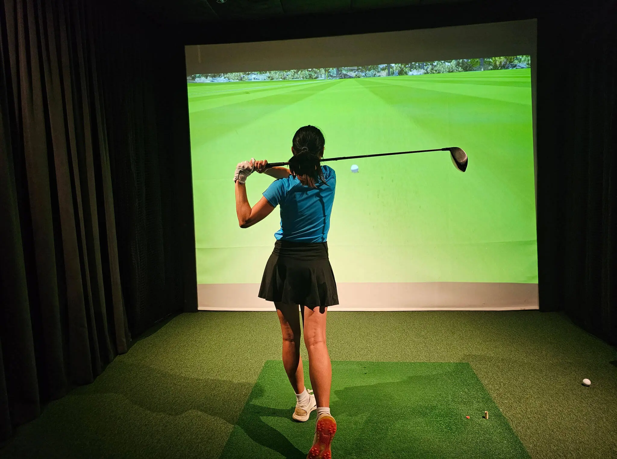 Golfer practicing with virtual simulator