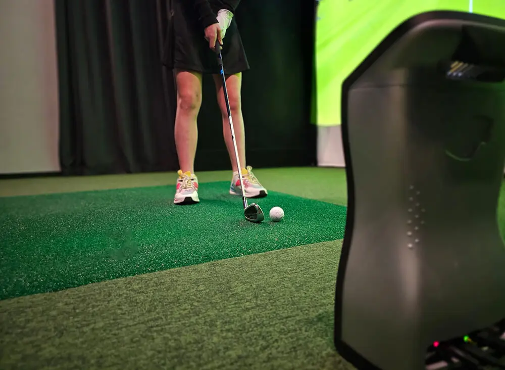 Person swinging golf club indoors